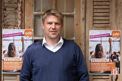 Tobias Ruff mit Plakat zur Petition "Bürgerwillen ernst nehmen - Demokratie stärken"